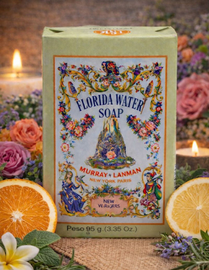 Florida Water Soap packaging with decorative design, surrounded by flowers and oranges on a wooden surface.