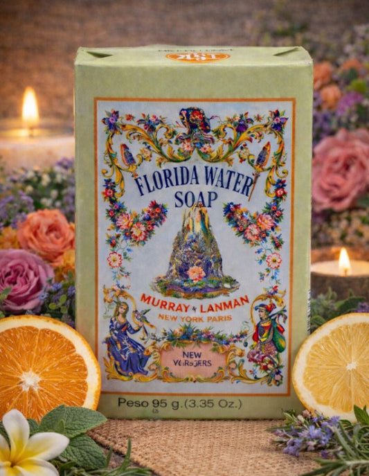 Florida Water Soap packaging with decorative design, surrounded by flowers and oranges on a wooden surface.