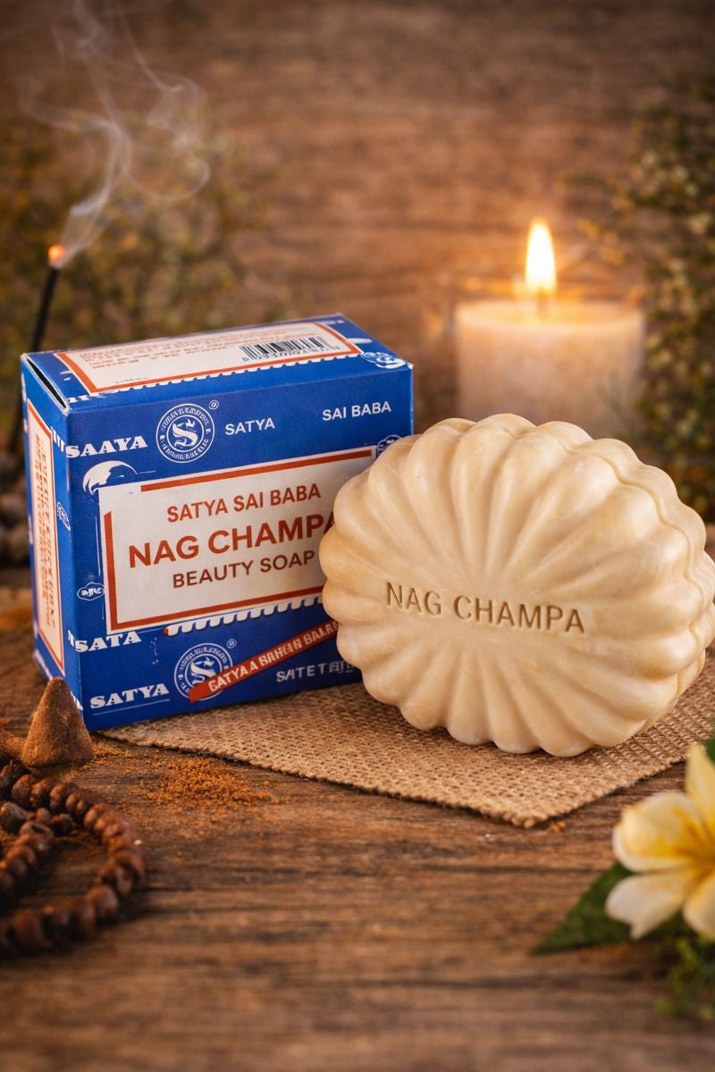 Satya Nag Champa soap and packaging on a wooden surface with a candle in the background