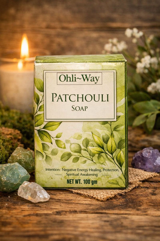 Ohli-Way Patchouli Soap packaging on a wooden surface with a candle and crystals in the background.
