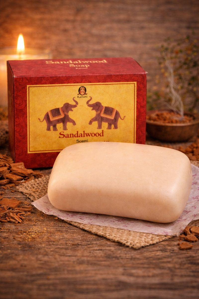 Bar of sandalwood soap with a red box featuring elephant designs on a wooden surface.