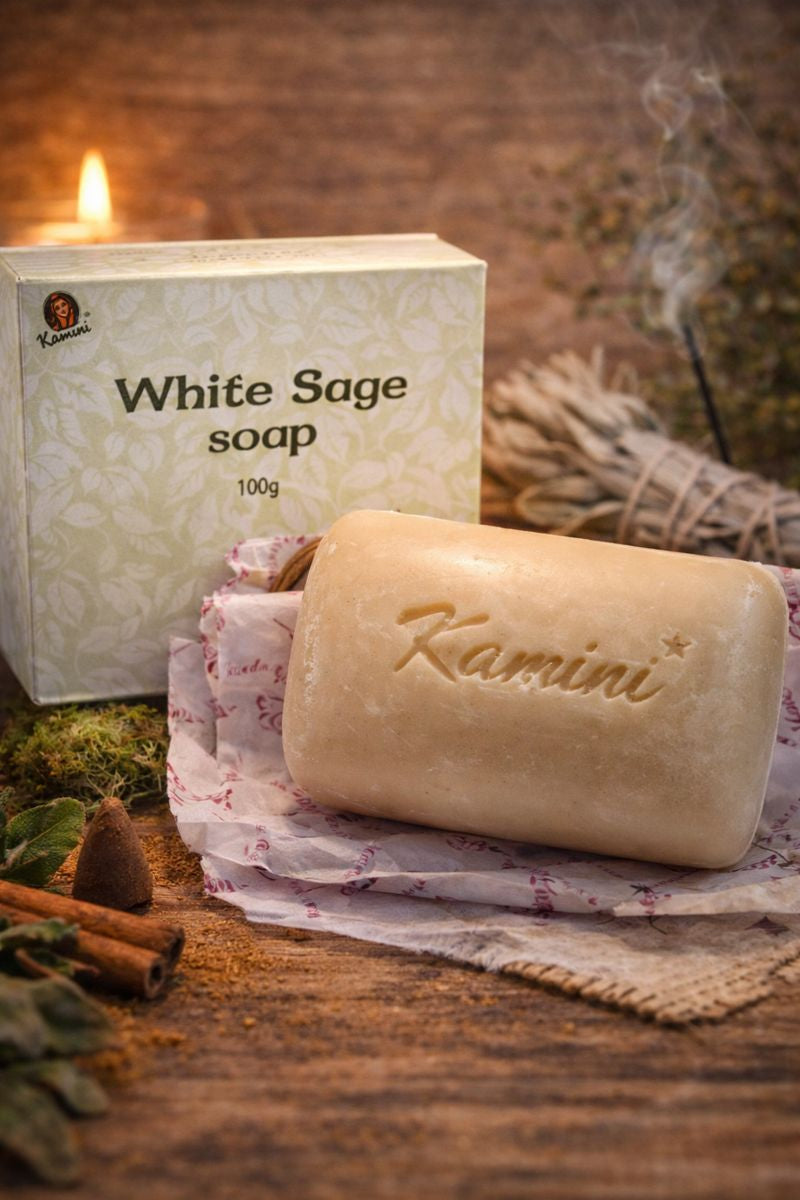 White Sage soap bar with packaging on a wooden surface, surrounded by cinnamon sticks and sage leaves.